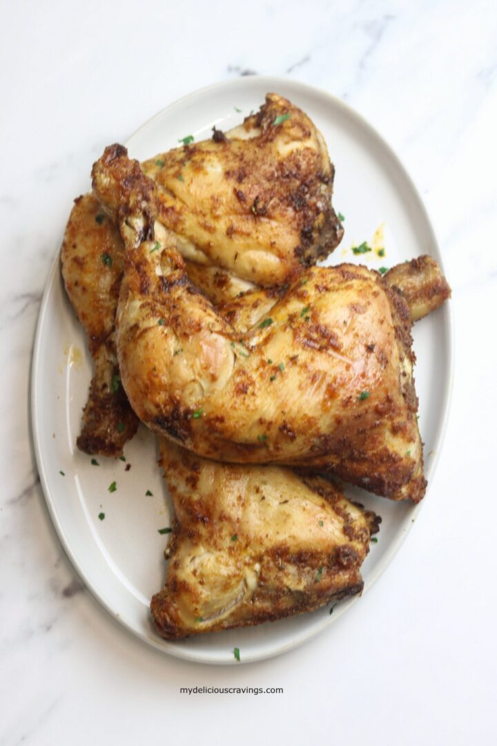 chicken leg quarters served in a white plate.