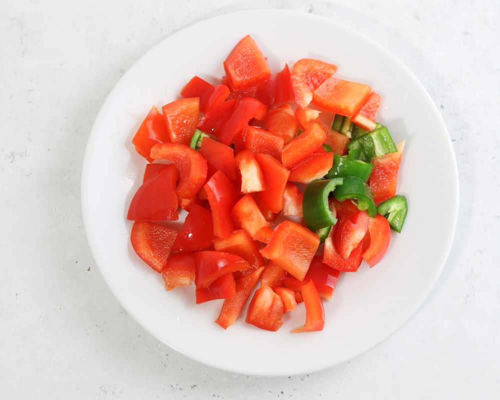 Diced red bell pepper and jalapeno in a white plate.